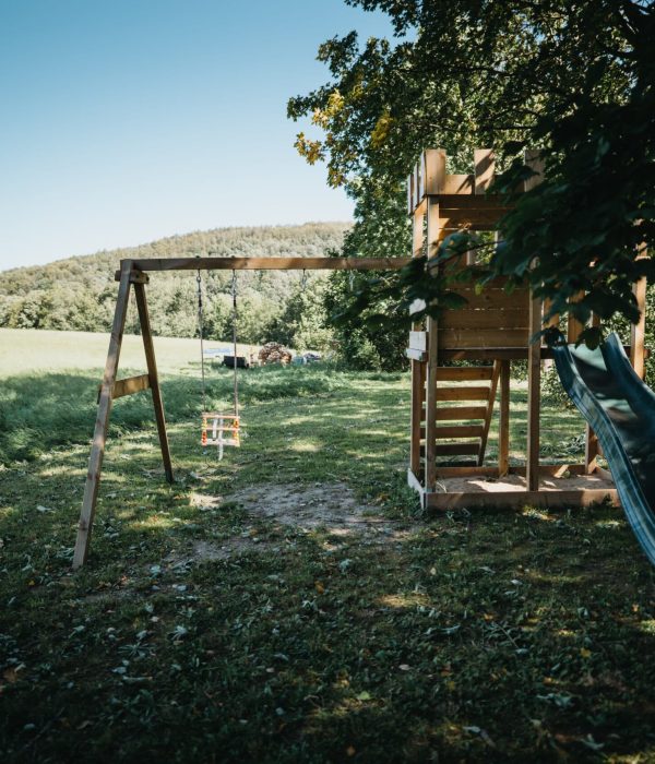 Dětské hřiště u penzionu – houpačky a skluzavka